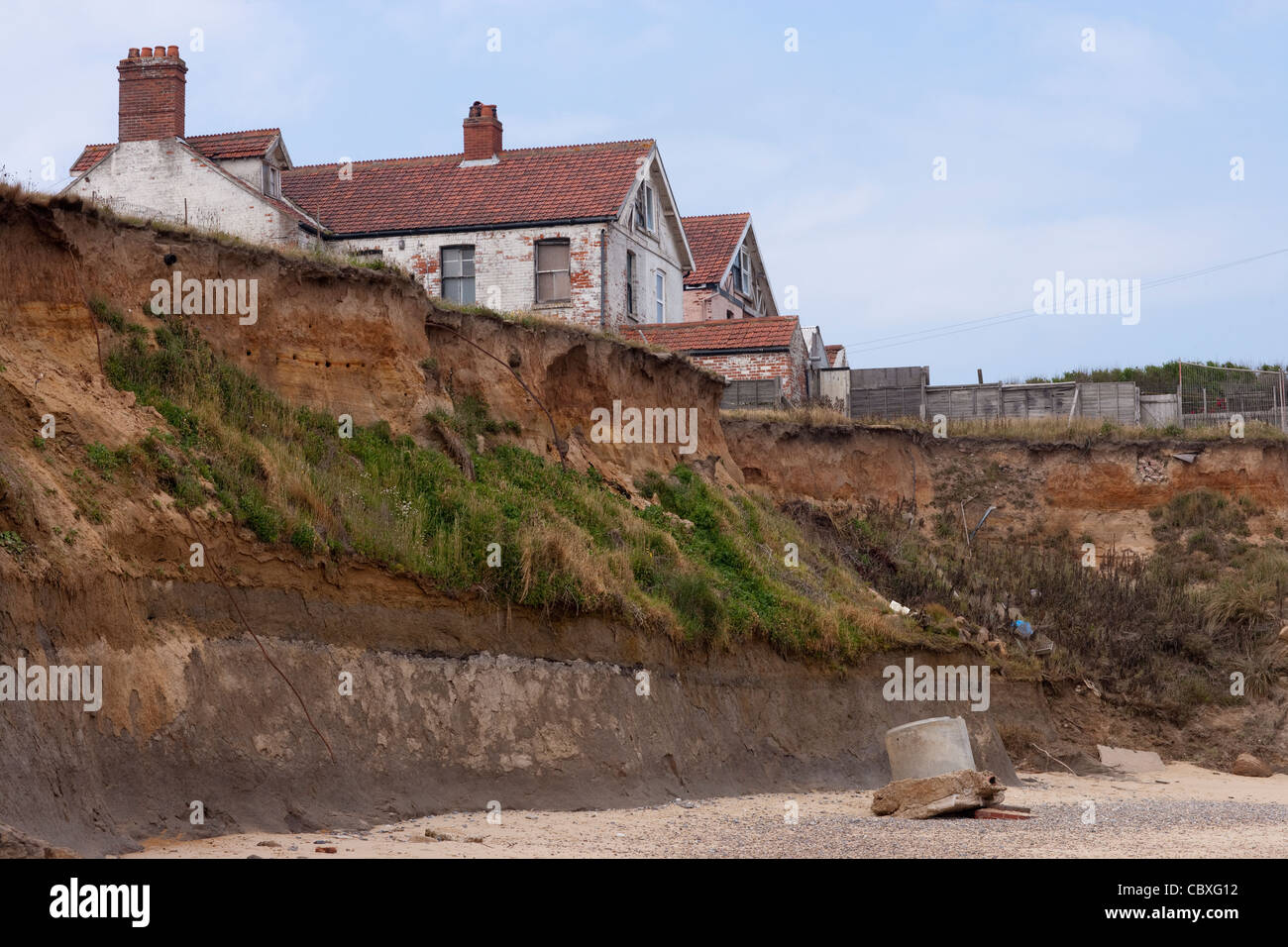 Happisburgh Küste, North Norfolk, East Anglia. Erosion der Felsen an der Nordsee; Wohnungen, Häuser, Wohnungen, Gebäude. Stockfoto