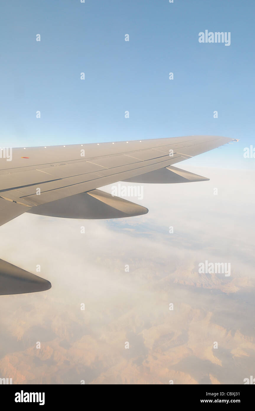 Foto von einem Jet-Flügel im Flug an einem blauen Himmel Morgen während des Fluges über die Rocky Mountains. Stockfoto