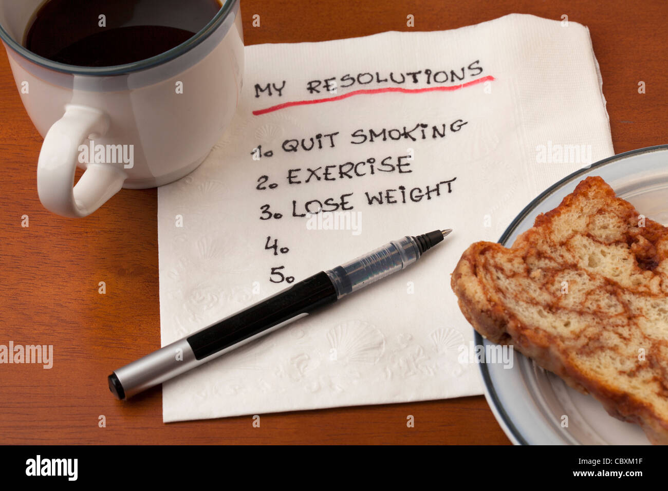 meine Liste Auflösung (Rauchen, Bewegung, Gewicht zu verlieren) Handschrift auf weiße Serviette mit Kaffeetasse und Kuchen am Tisch Stockfoto