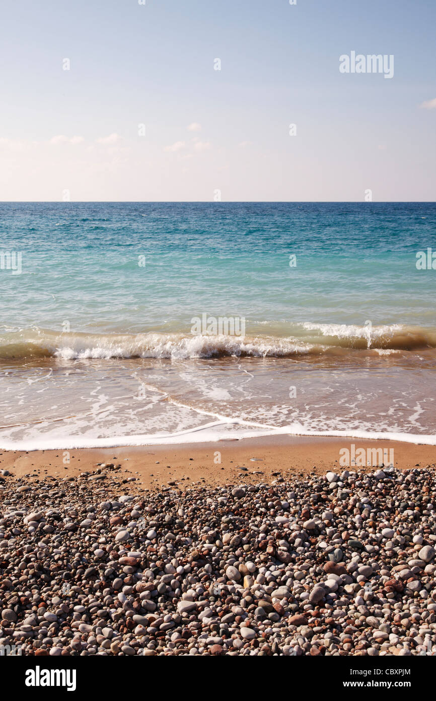 Generische Seeseite mit Kieselsteinen, Sand, Brandung, Meer und Himmel. Copyspace Stockfoto