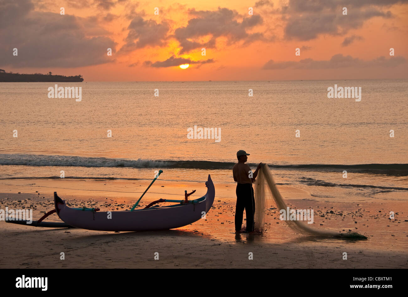 Fischer am Strand von Jimbaran bei Sonnenuntergang, Bali, Indonesien. Stockfoto