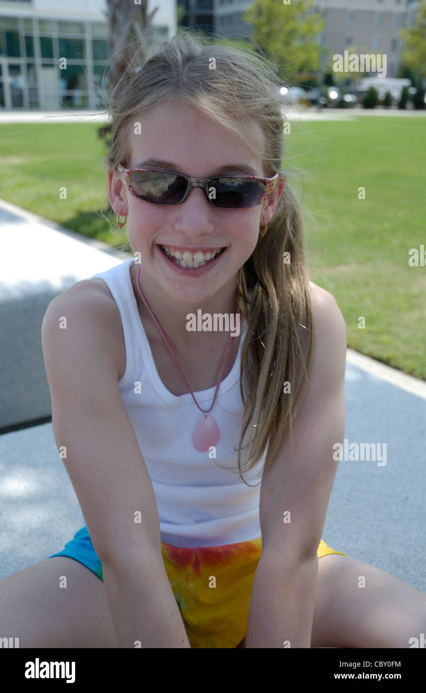 Foto eines attraktiven jungen Mädchen sitzen im Schatten. Stockfoto