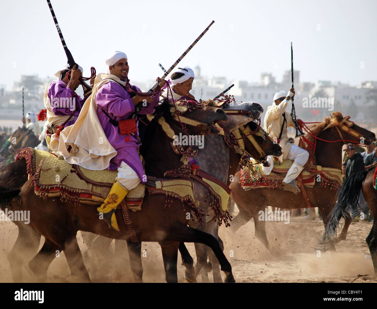 Berber Reiter anzeigen ihre Fähigkeiten mit Pferd und Gewehr am Strand von Essaouira in Marokko. Stockfoto