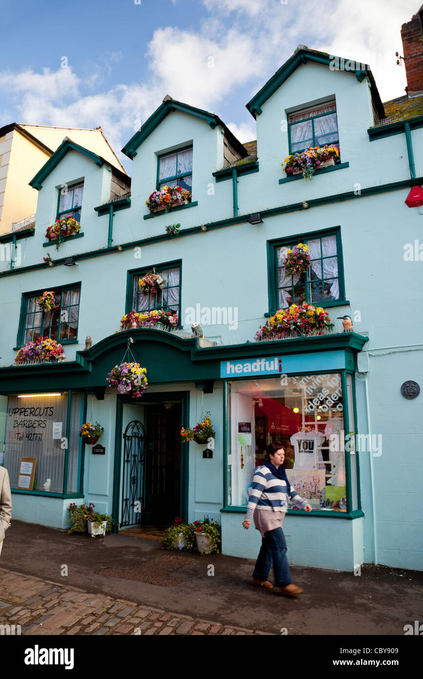 Eine bunte Anzeige von Plastikblumen in Balkonkästen über einem Geschäft in Bridport, Dorset, England, UK Stockfoto