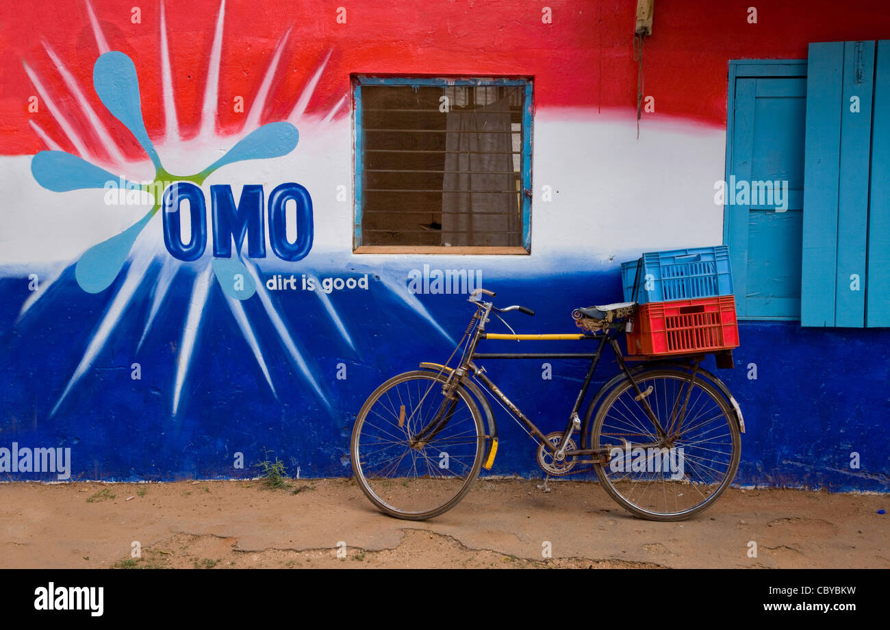Farbenfrohe Gebäude in Südkenia Voi Werbung Omo Waschpulver mit einem Fahrrad Lieferung außerhalb Stockfoto