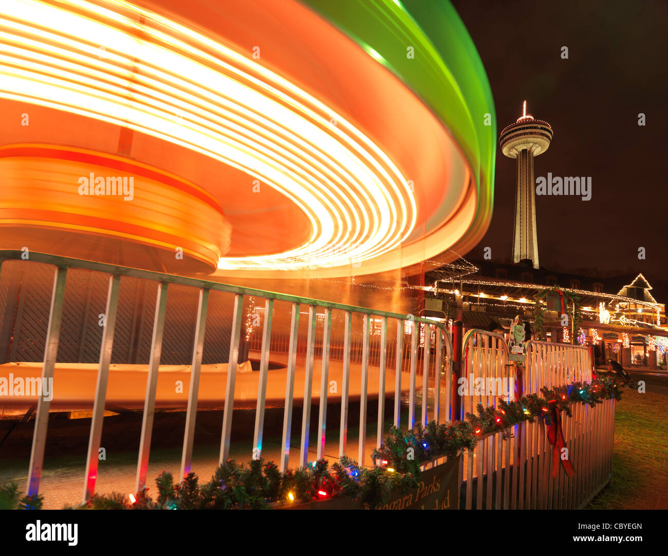 Drehenden Karussell Karussell Weihnachtszeit an den Niagarafällen mit Skylon Tower im Hintergrund. Ontario, Kanada Stockfoto