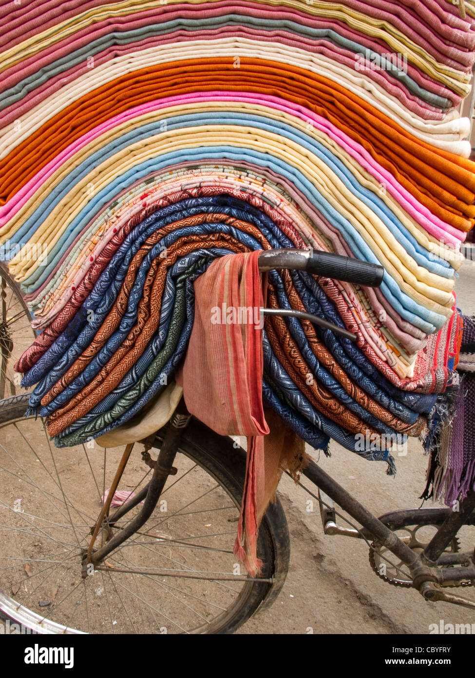 Indien, Bihar, Bodhgaya, Stapel von Textilien für den Verkauf an Pilger am Lenker des Fahrrads Stockfoto