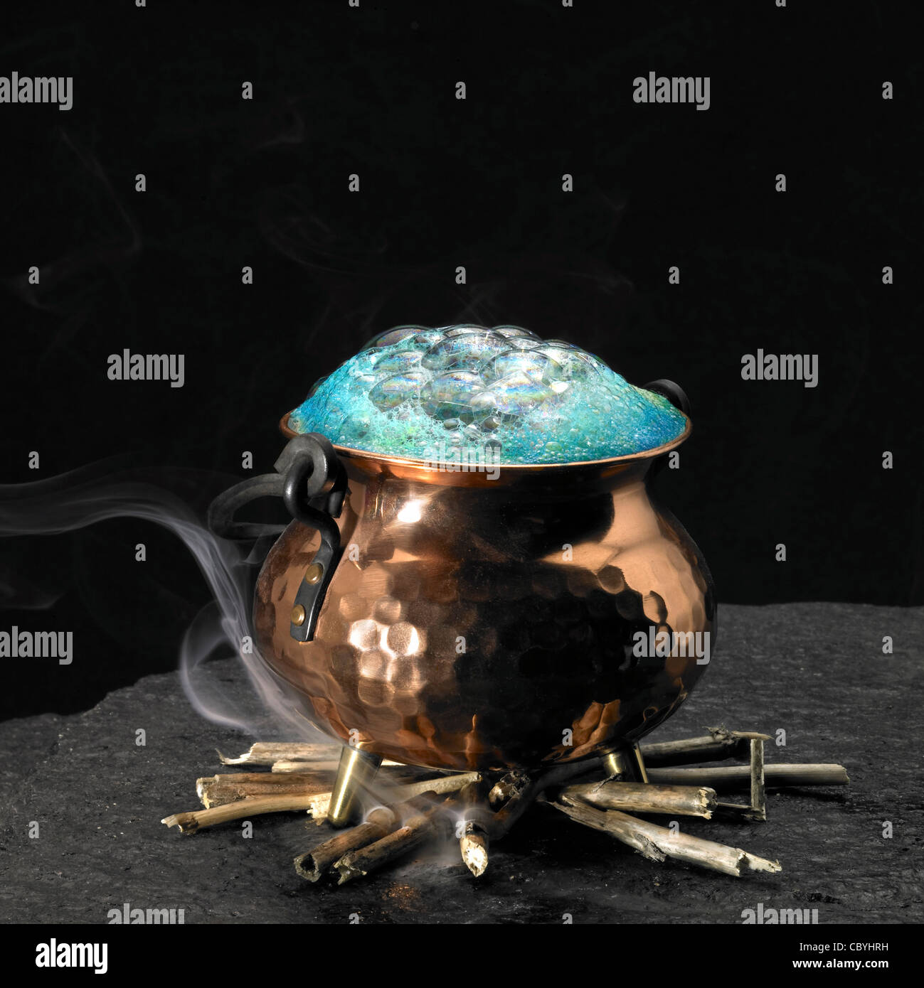 symbolisches Bild mit schäumende trank und Kupfer Kessel auf einem Kamin Stockfoto