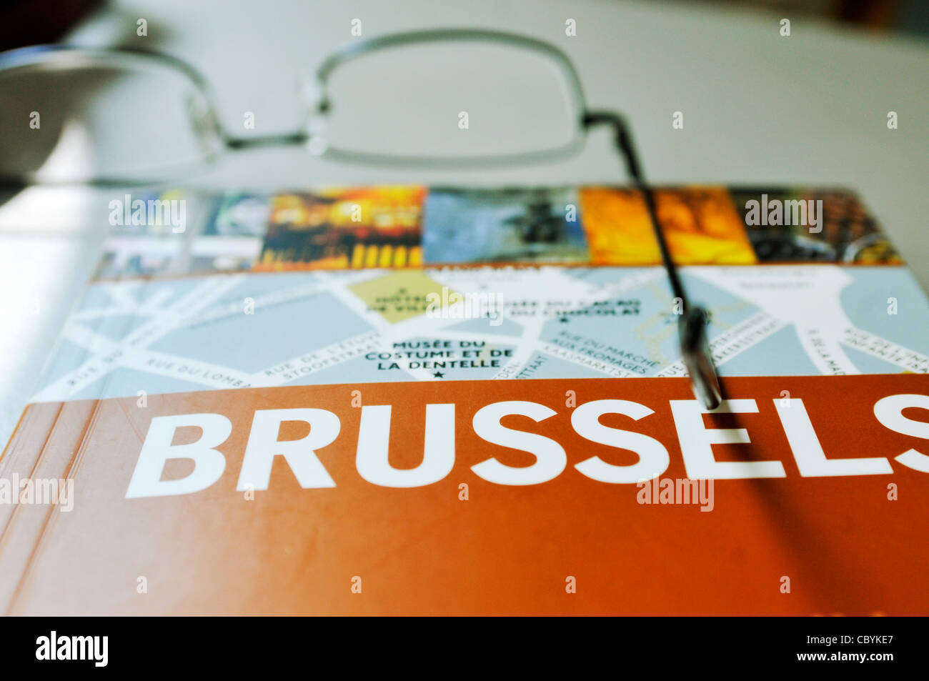 Nahaufnahme von einem touristischen Reiseführer nach Brüssel mit Brille Stockfoto