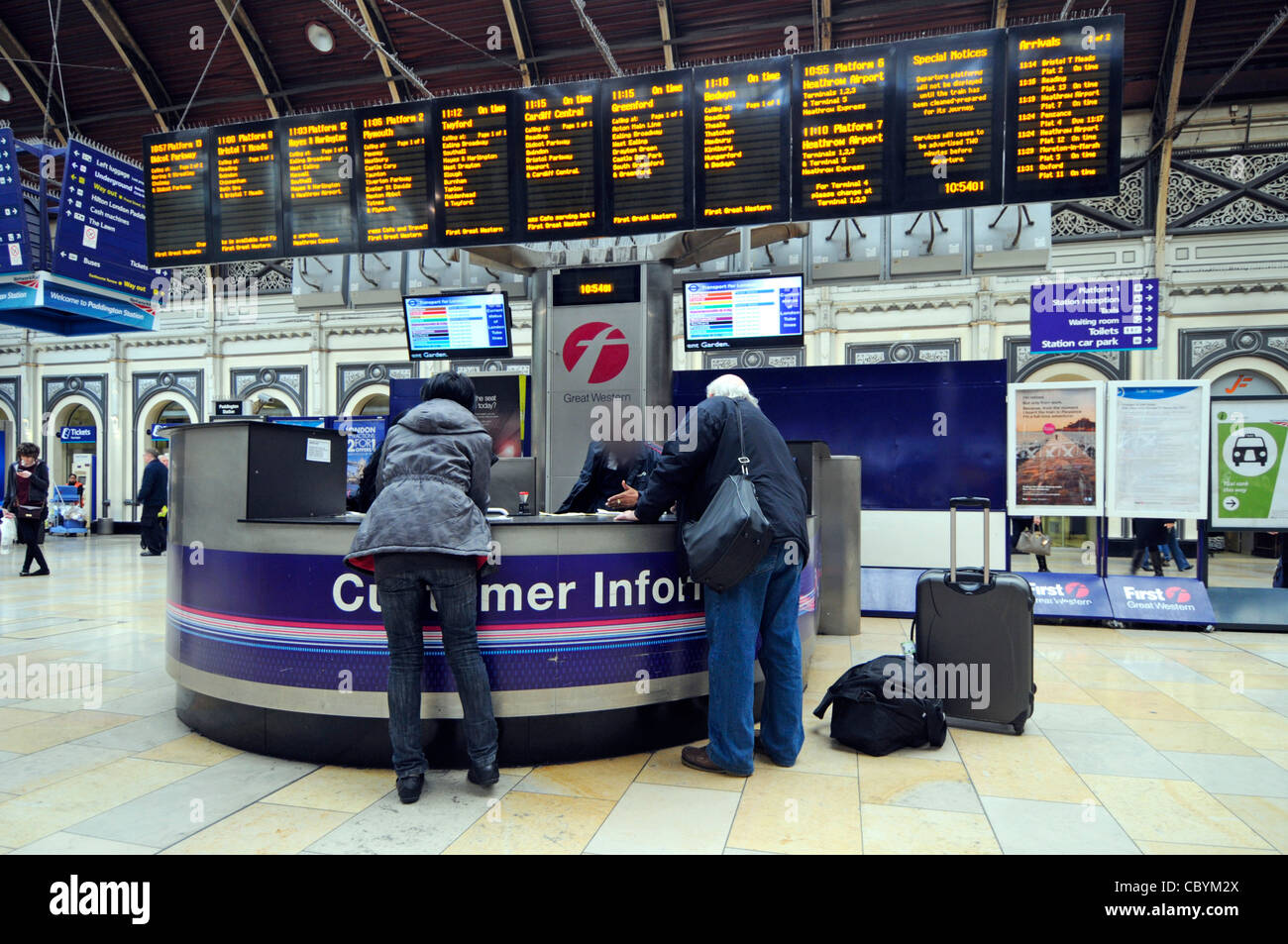 Bahnreisende erhalten Hilfe beim Kunden Informationen Service Desk am Paddington Bahnhof (Personal verdeckt Gesicht) London England Großbritannien Stockfoto