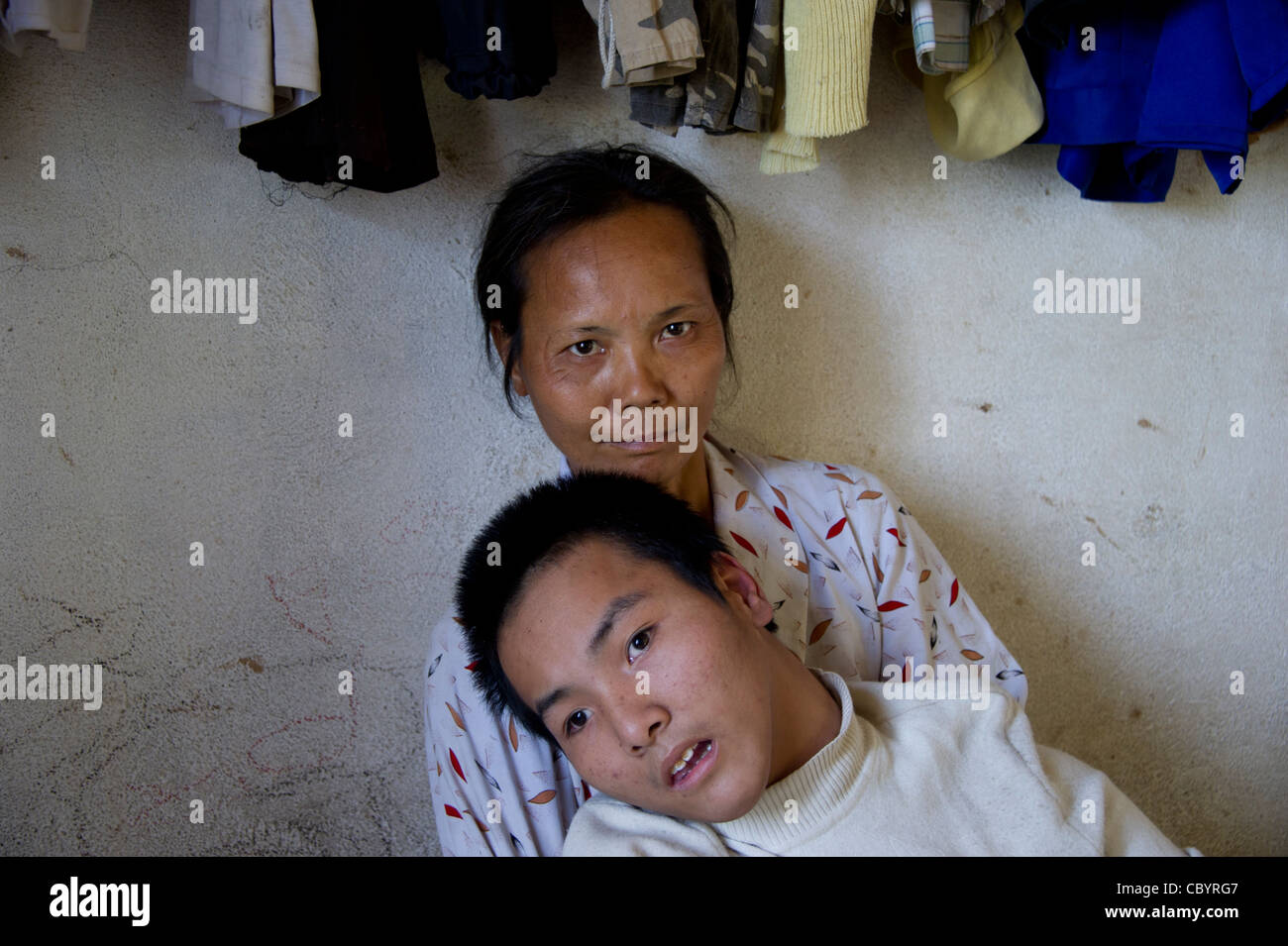 Porträt einer Mutter mit ihrem Jugendlichen behinderten Sohn, Vietnam. Stockfoto