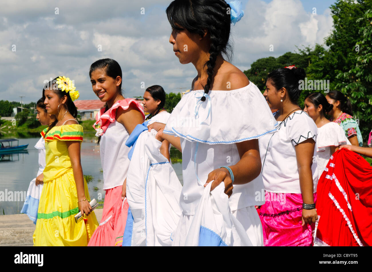 Parade zum Unabhängigkeitstag von Guatemala // FLORES, Guatemala — Eine Gruppe junger Frauen in traditionellen Kleidern aus der Kolonialzeit kommt am 15. September 2011 im Rahmen der Feierlichkeiten zum Unabhängigkeitstag von Guatemala vorbei. Gruppen von Schülern ziehen in einer Prozession durch die Straßen von Flores, beginnen im Parque Central, gehen durch die Stadt und überqueren den Damm nach Santa Elena. Stockfoto
