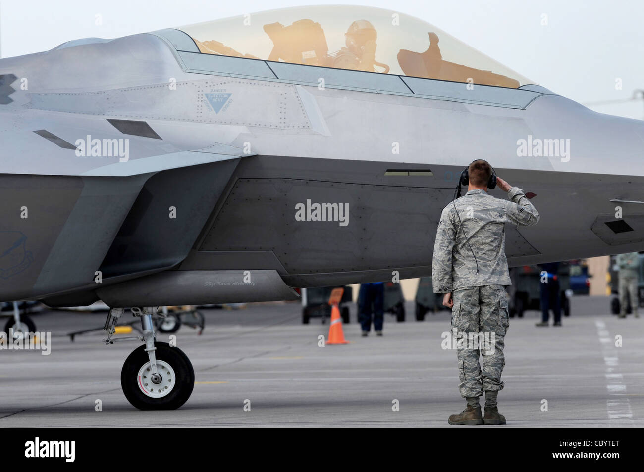 Airman 1st Class Justin Horne begrüßt einen F-22 Raptor Piloten 4. Februar 2010, während einer Red Flag Training Übung auf der Nellis Air Force Base, Nev. Red Flag ist eine realistische Kampftraining Übung mit den Luftstreitkräften der Vereinigten Staaten und ihren Verbündeten, Und auf dem 15,000 Quadratmeter großen Nevada Test and Training Range nördlich von Las Vegas durchgeführt. Der Flugmann Horne wird dem 49. Flugzeugwartungsgeschwader auf der Holloman AFB, N.M., zugewiesen Stockfoto