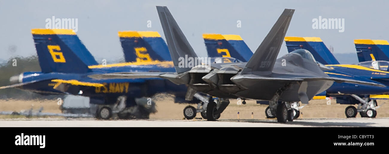 Ein F-22 Raptor setzte die Hitze auf die F/A-18 Hornets der Blue Angels, während sie am AirFest 2008 im Kelly Field Annex der Lackland Air Force Base, Texas, am 31. Oktober 2008 an ihnen vorbeirollten. Stockfoto