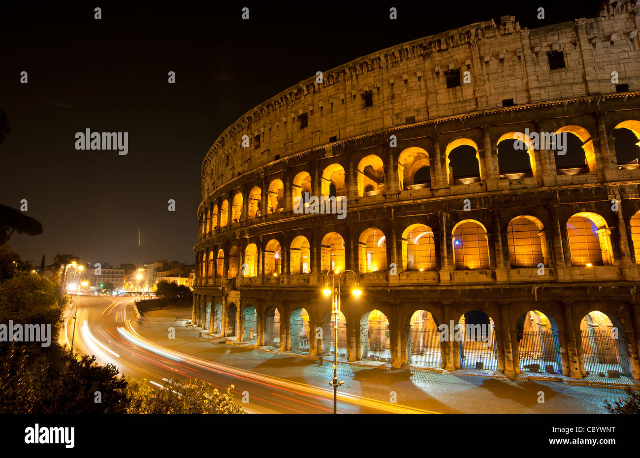 Datenverkehr um das Kolosseum in Rom, Italien nach Einbruch der Dunkelheit. Stockfoto