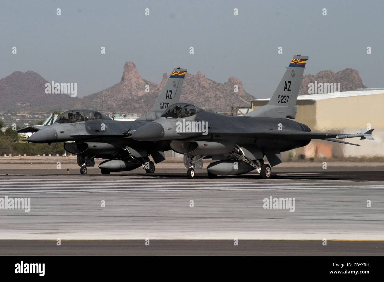 Am Ende der Start- und Landebahn am Tucson International Airport bereitet sich ein F-16 Fighting Falcon Instructor Pilot mit dem 162. Fighter Wing der Arizona Air National Guard auf den Start mit seinem Flügelmann vor, einem internationalen studentischen Pilotentraining mit der Guard-Einheit. Stockfoto