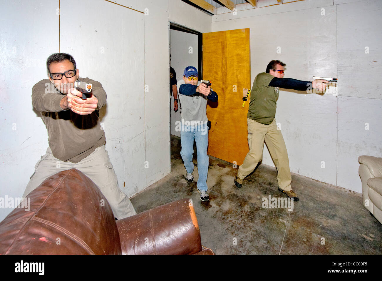 Unter den Augen eines Lehrers üben Strafverfolgungsbehörden eingeben oder "Verletzung" ein Zimmer mit Waffen. Stockfoto