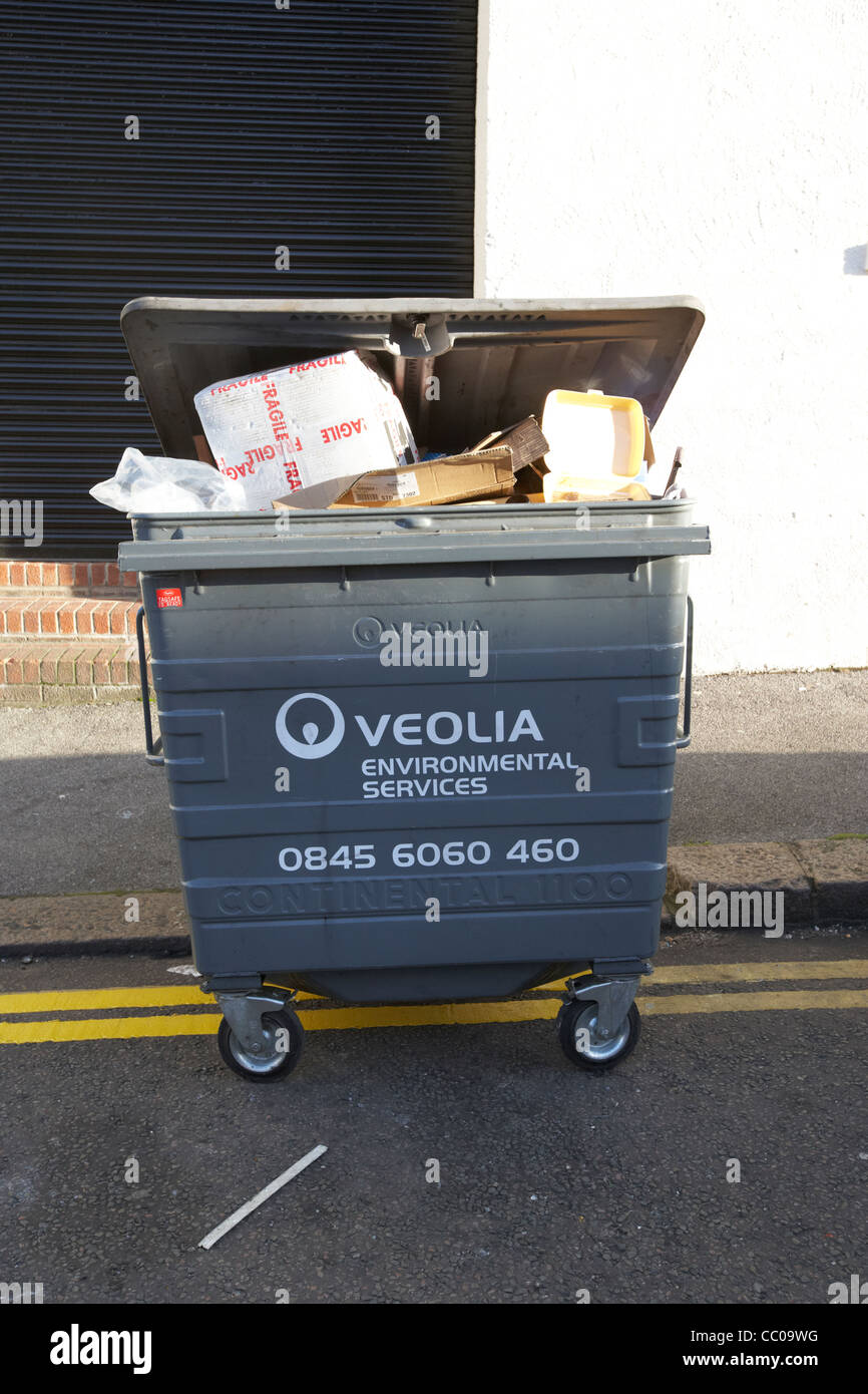 Veolia Umweltdienstleistungen große kommerzielle Abfallbehälter überfüllt mit Müll auf einer Straße in London England UK Stockfoto