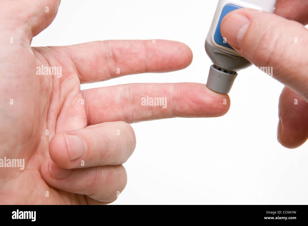 Eine Lanzette findet gegen einen Finger für eine Blutzuckermessung verwendet werden. Stockfoto