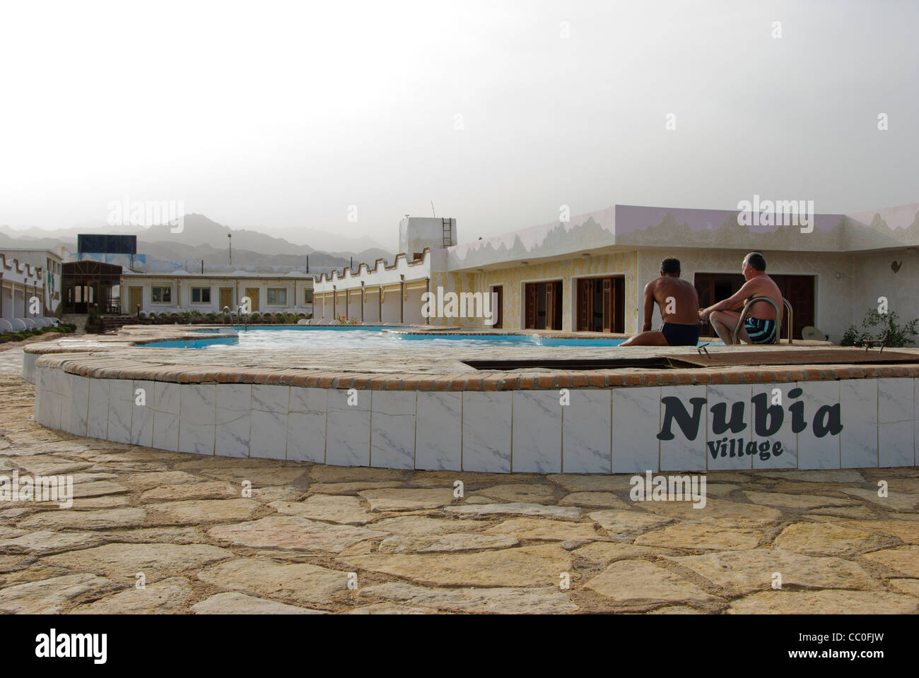 Zwei Touristen sitzen in der Nähe eines Swimmingpools Nubien Village Resort in Dahab - Sinai-Halbinsel, Ägypten Stockfoto