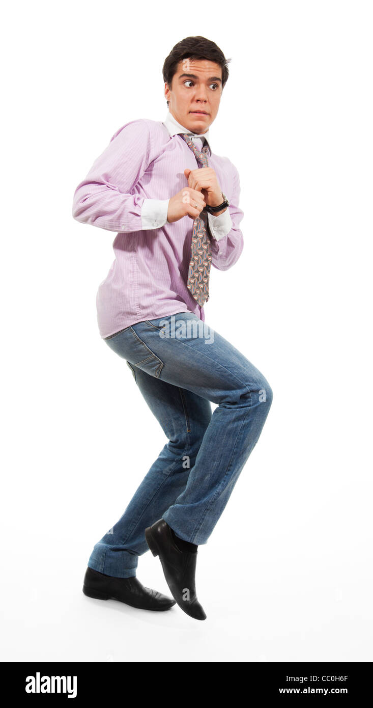 Ein Mann mit Angst Gesichtsausdruck, schleichen in Jeans, Hemd und Krawatte, isoliert auf weiss Stockfoto
