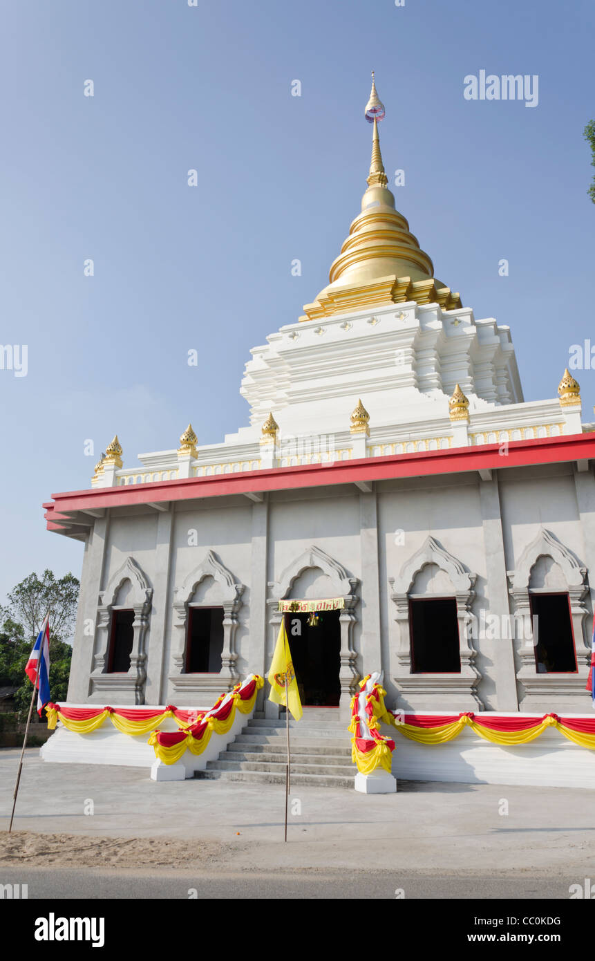 Buddhistischer Tempel im Bau, geschmückt mit Girlanden und Fahnen mit goldenen Stupa in Nordthailand Stockfoto