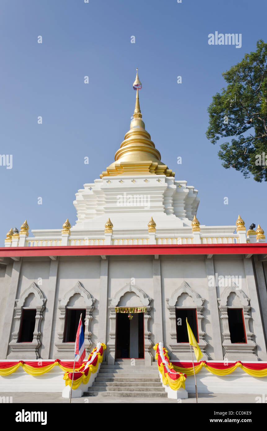 Buddhistischer Tempel im Bau, geschmückt mit Girlanden und Fahnen mit goldenen Stupa in Nordthailand Stockfoto