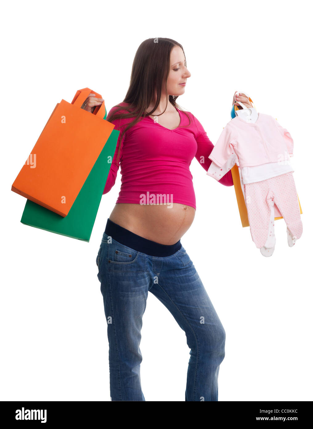 Schwangere Frau shopping für neue Baby stehend mit Kleidung und Taschen Stockfoto