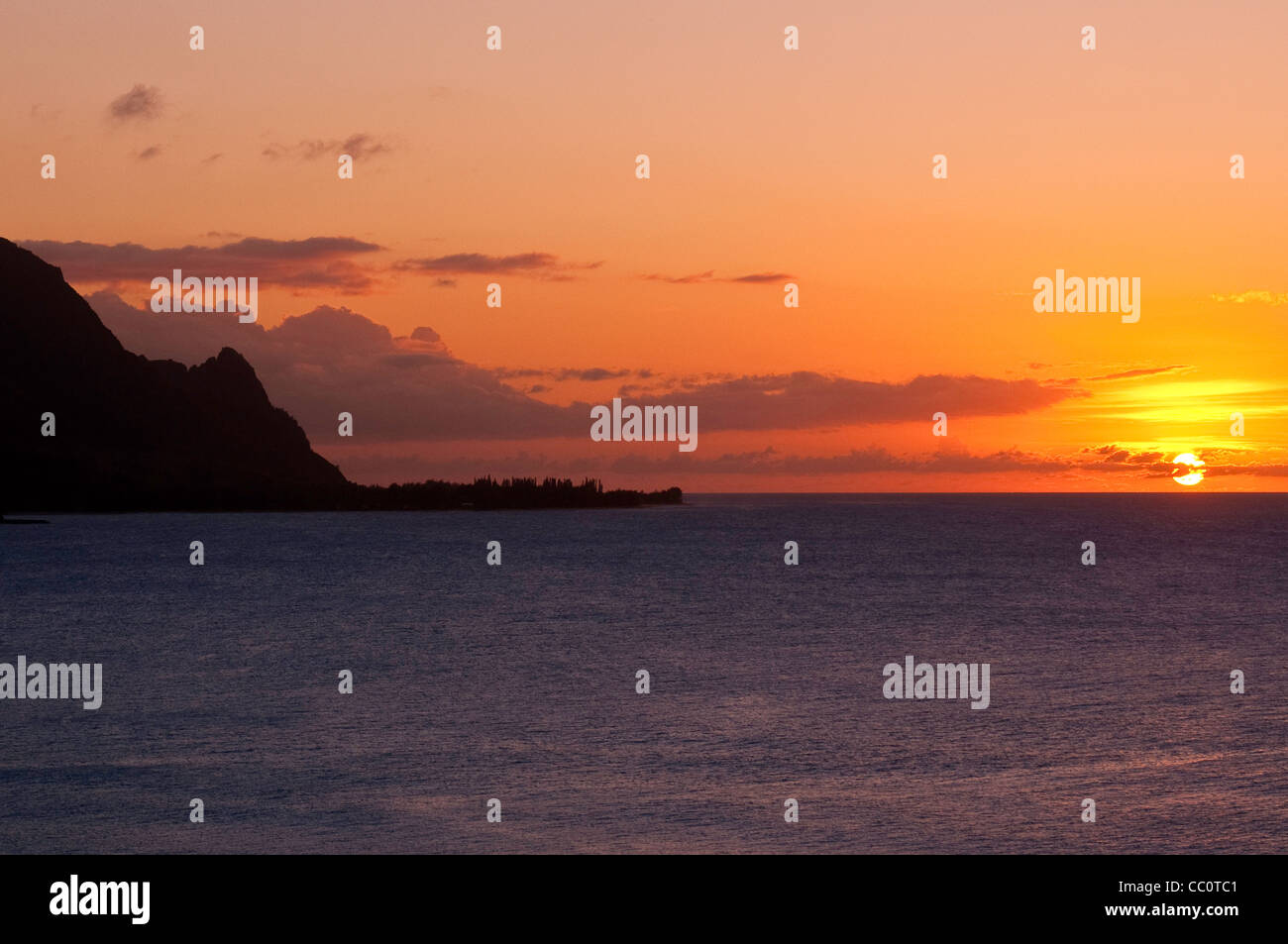 Sonnenuntergang am schwarzen Sandstrand Punaluʻu Strand auf der grossen Insel von Hawaii. Stockfoto