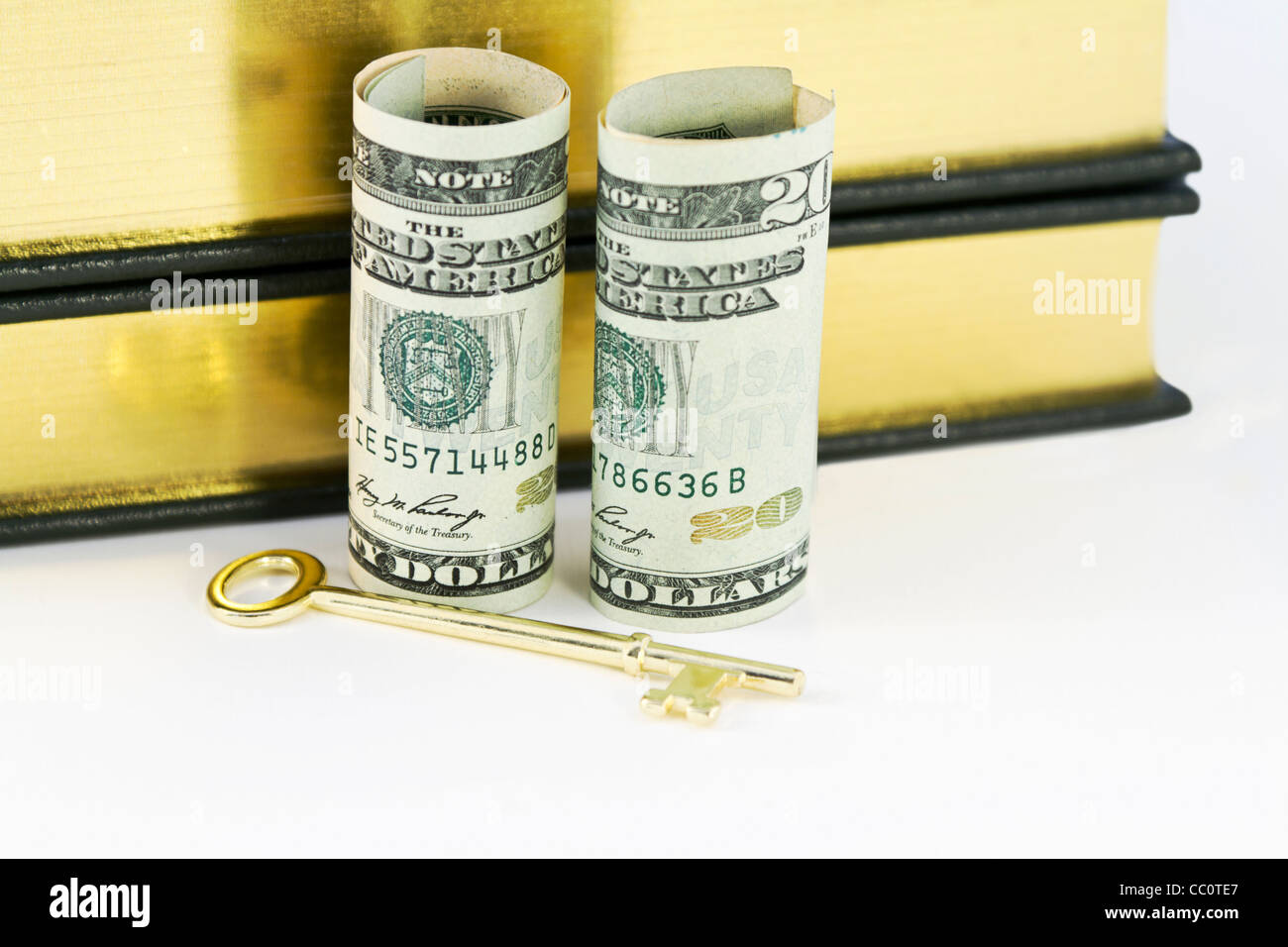 Legendärer goldenen Schlüssel des Erfolges vor stehenden Dollar gegen Bücher mit Gold umrandeten Seiten platziert Stockfoto