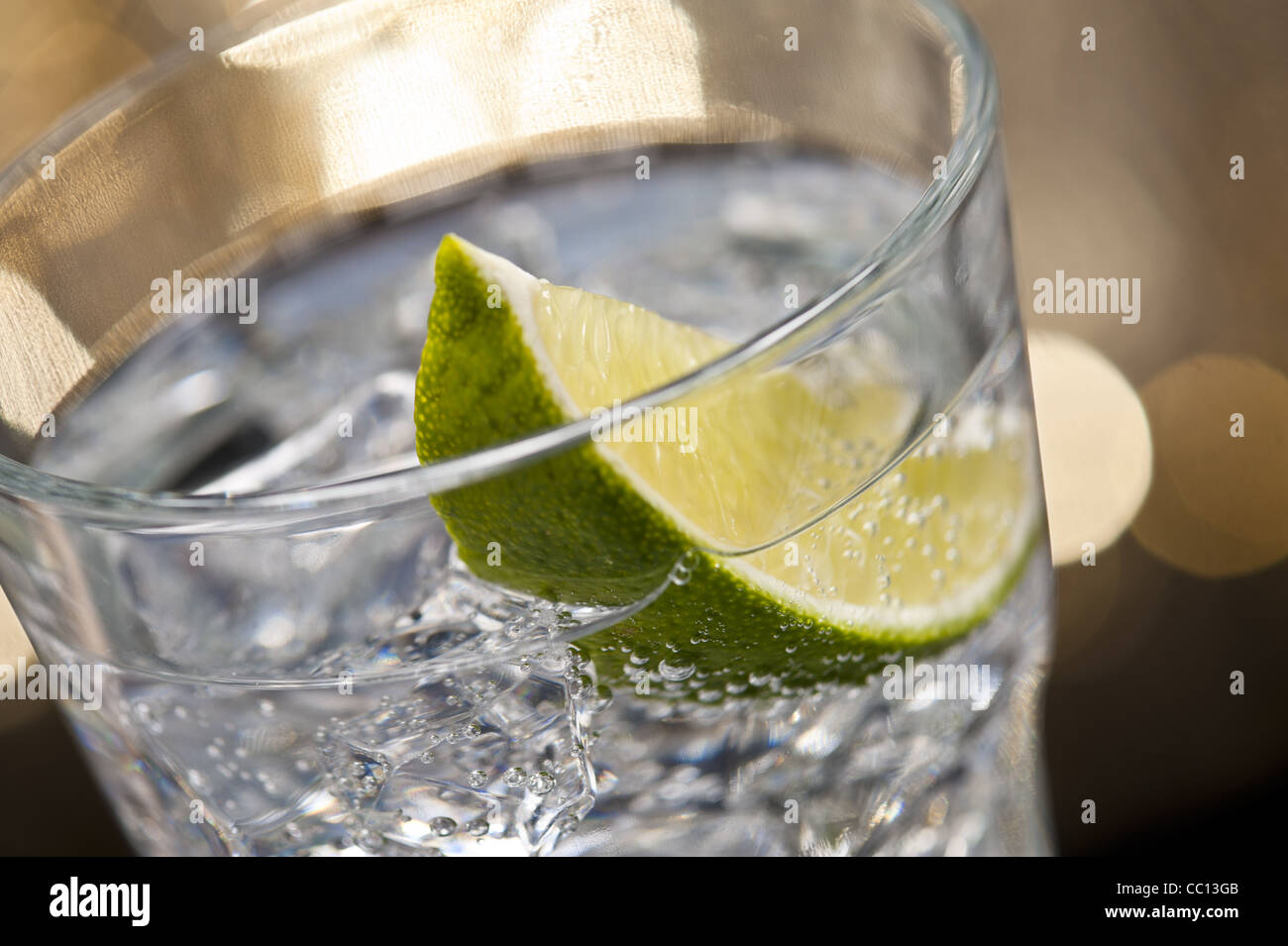 Gin Tonic Cocktail vor einem braunen gold Hintergrund Stockfoto