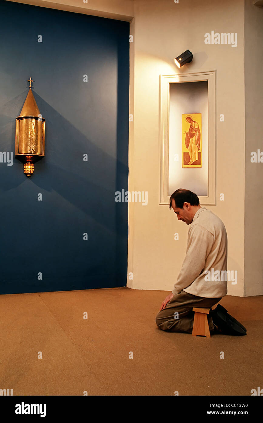 Mann, der betet in Kapelle Stockfoto