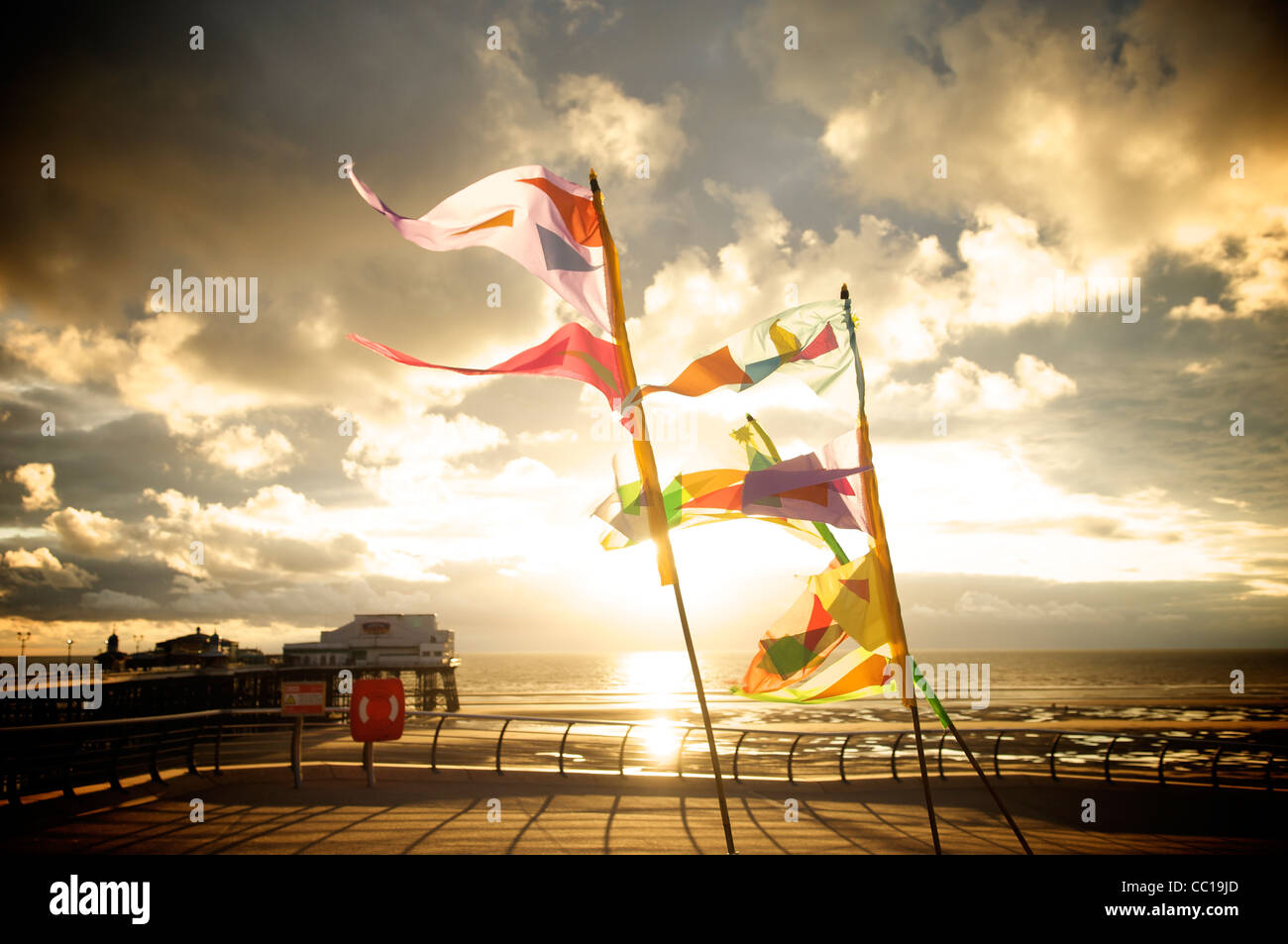 Dramatische skyColorful Flaggen im Wind flattern auf der Promenade in Blackpool bei Sonnenuntergang Stockfoto
