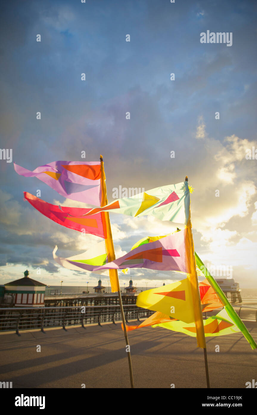 Bunte Fahnen im Wind flattern auf der Promenade in Blackpool bei Sonnenuntergang Stockfoto