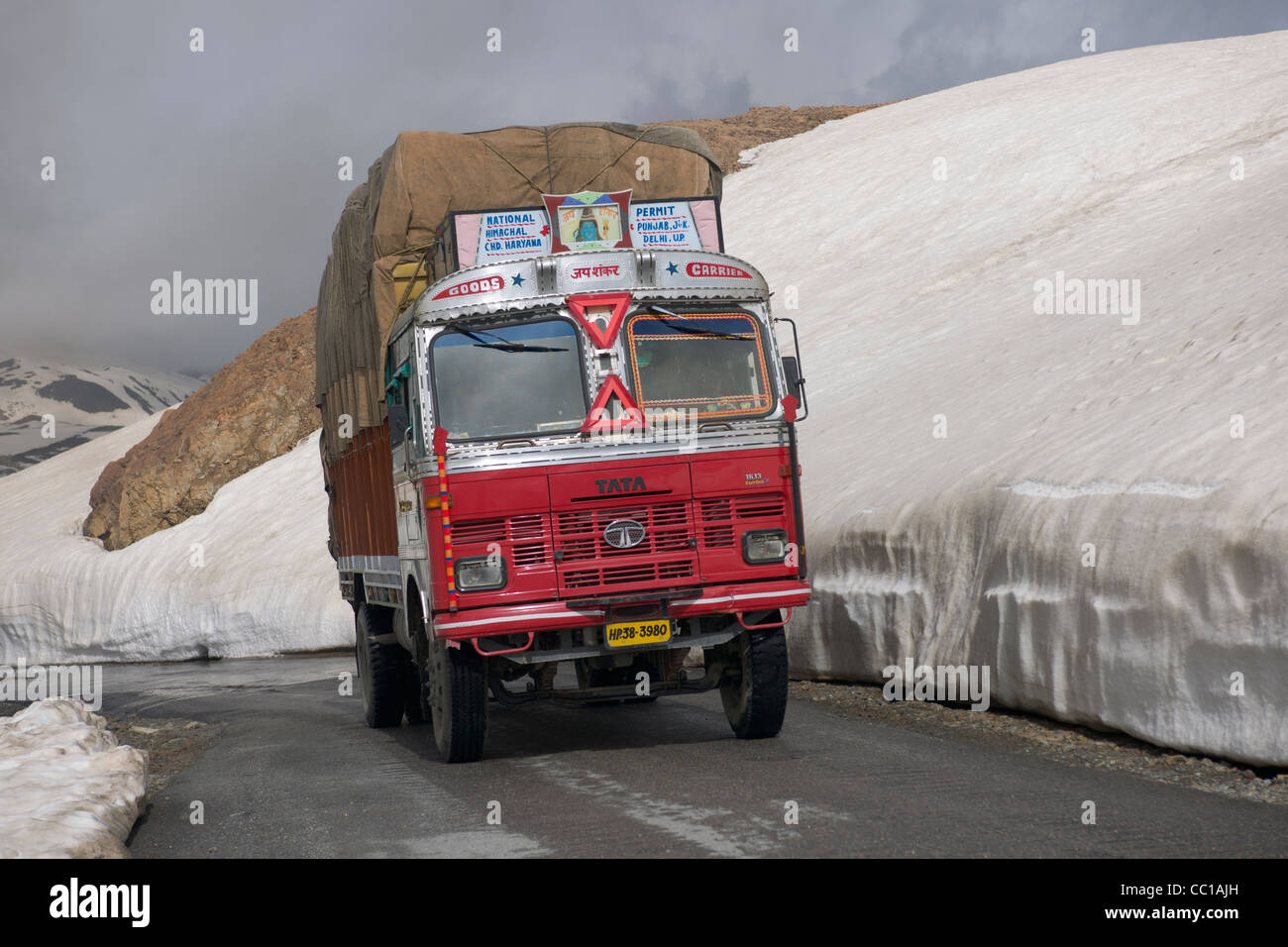 Tata Lkw vorbeifahren Schnee driftet durch den Straßenrand, Baralach La Pass Manali-Leh Highway, Himachal Pradesh, Indien Stockfoto