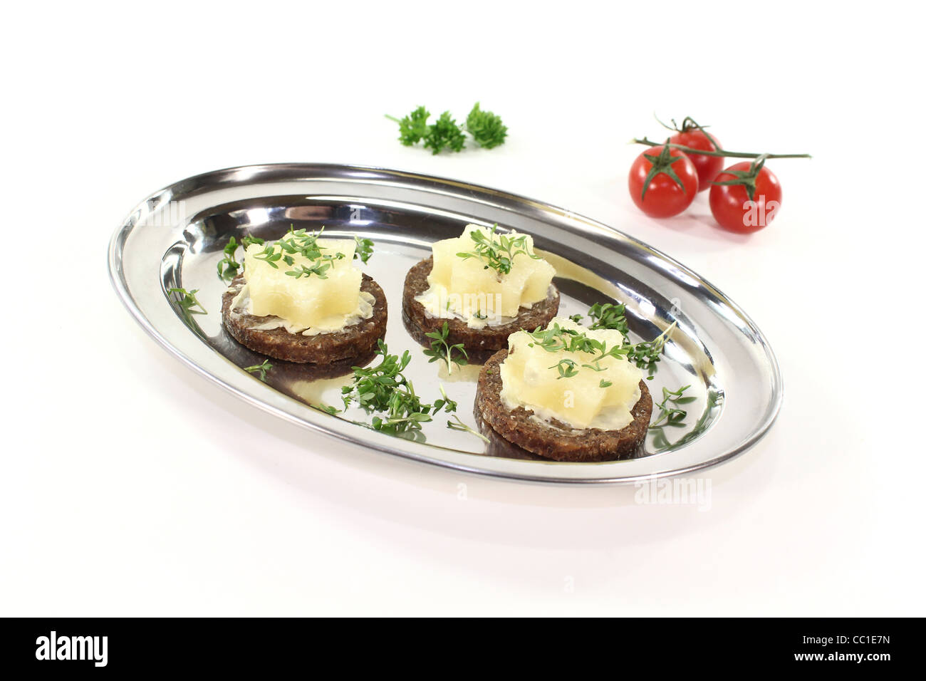 Pumpernickelbrot mit Butter, Harzer Käse und Gartenkresse auf einem silbernen Tablett Stockfoto