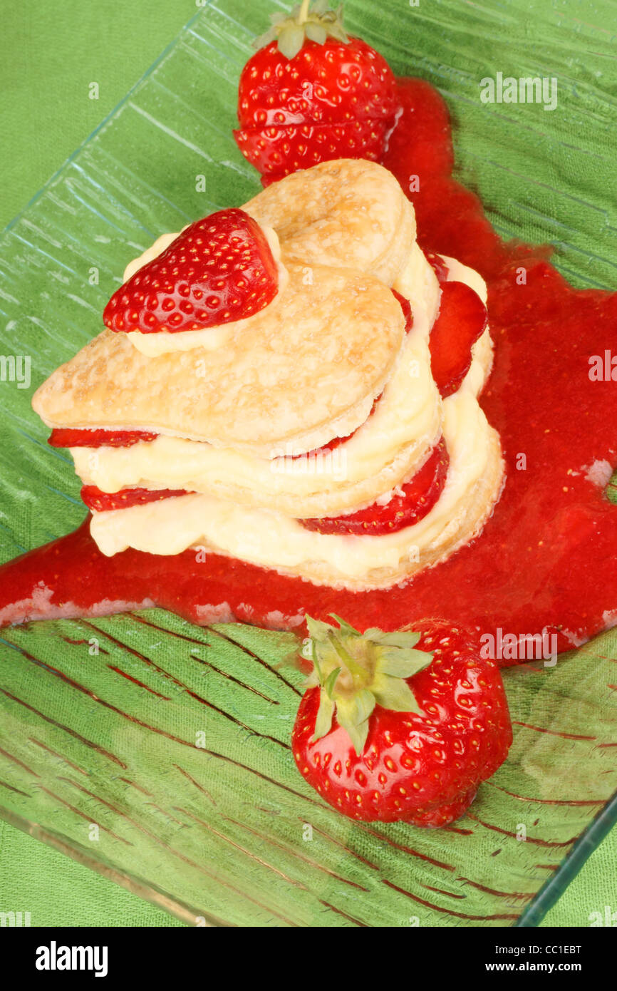 Herzförmige, Erdbeeren und Creme Millefeuille auf ein Erdbeer-sauce Stockfoto