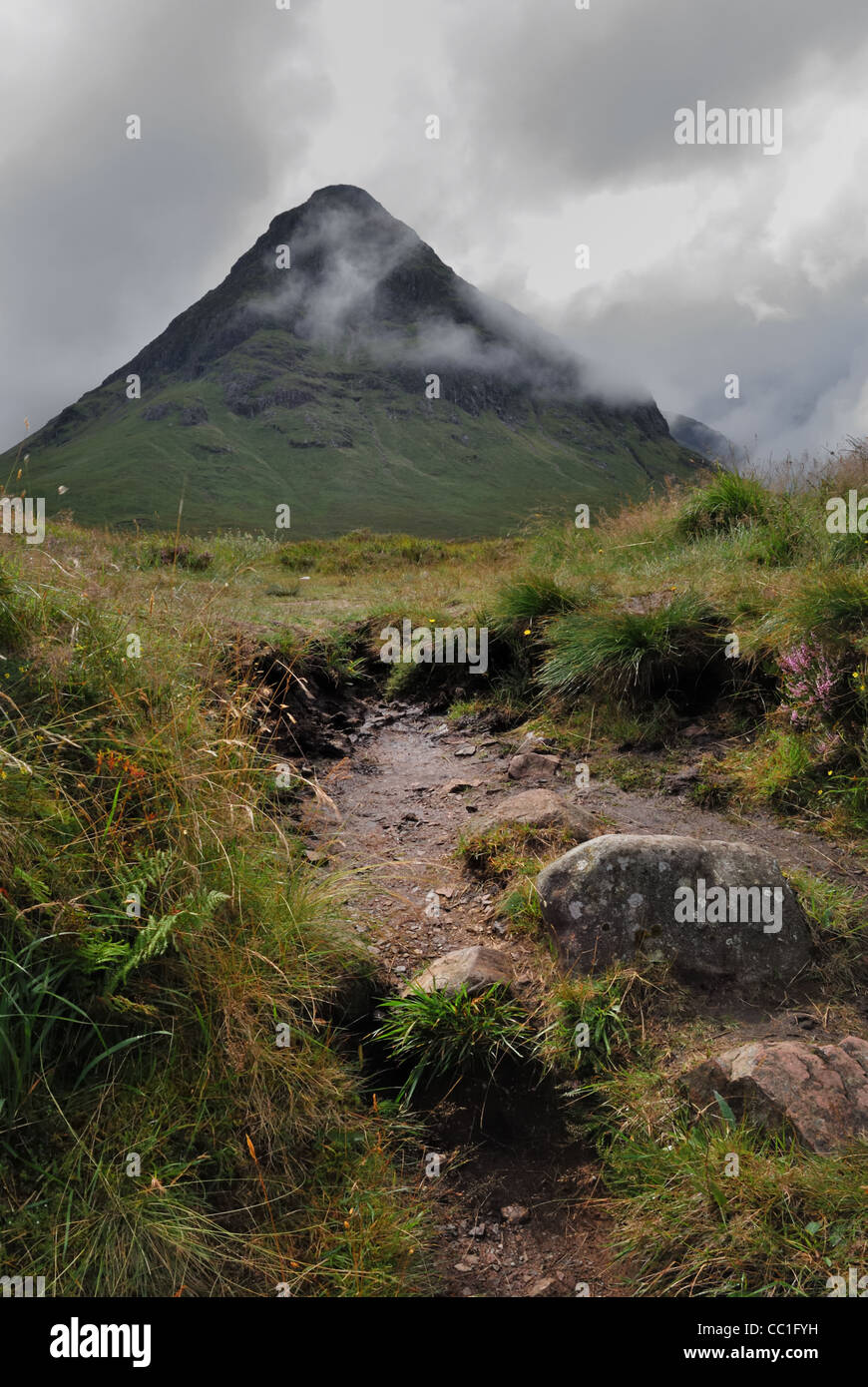Der Höhepunkt der Buachaille Etive Beag in den Highlands von Schottland, dominiert die Aussicht mit einem gut ausgetretenen Pfad im Vordergrund. Stockfoto