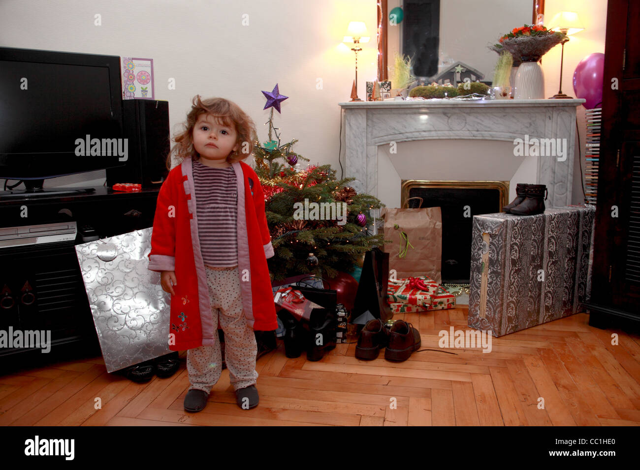 36 Monate altes Mädchen öffnen ihre Geschenke für Weihnachten Stockfoto