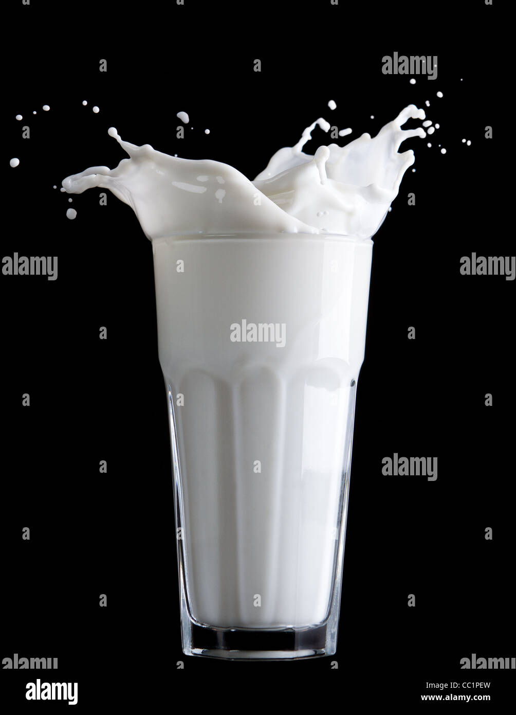 Glas Milch und Milch Spritzen auf schwarzem Hintergrund Stockfoto