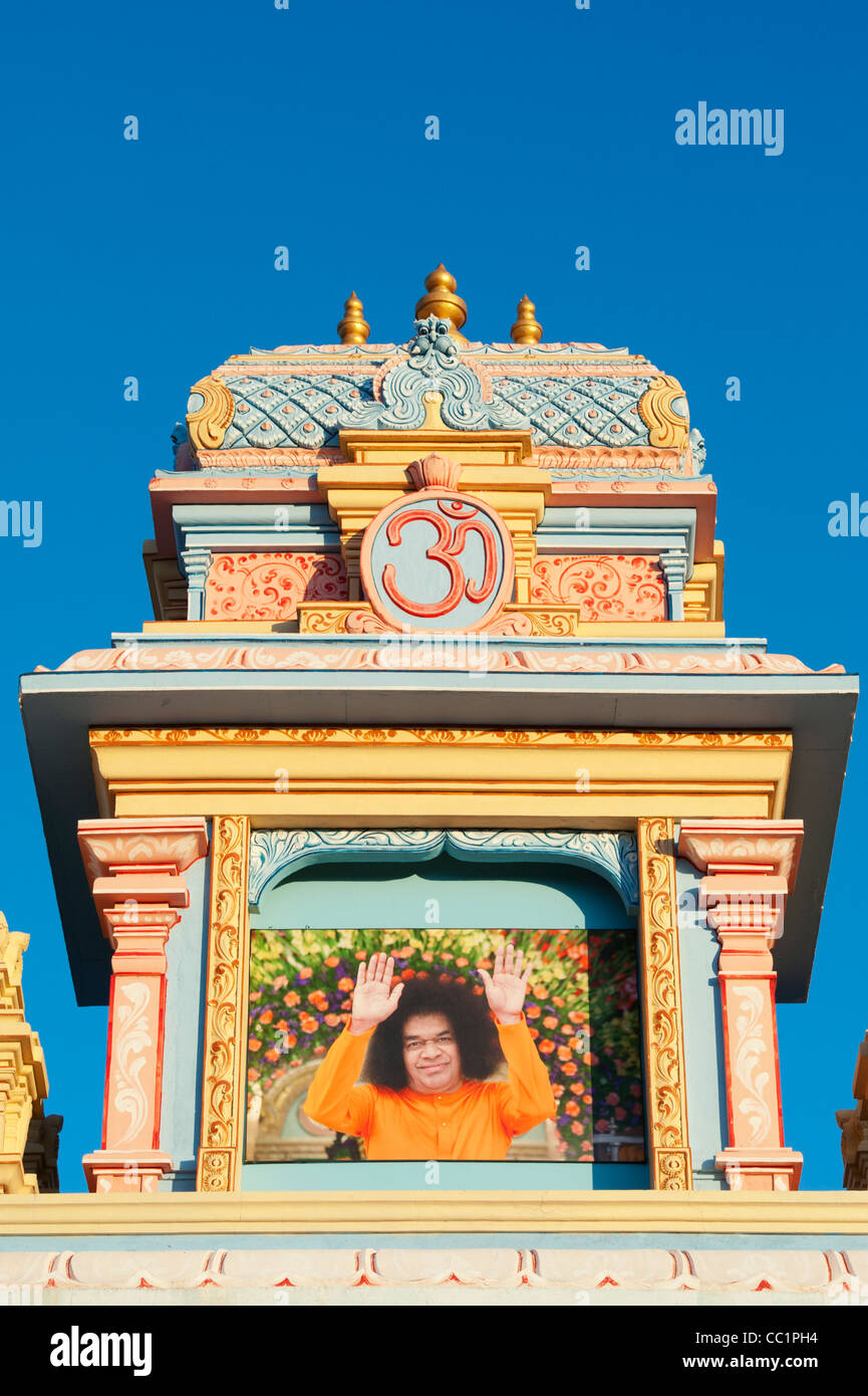 AUM Torbogen mit Sathya Sai Baba Bild gegen blauen Himmel gemalt. Puttaparthi, Andhra Pradesh, Indien Stockfoto