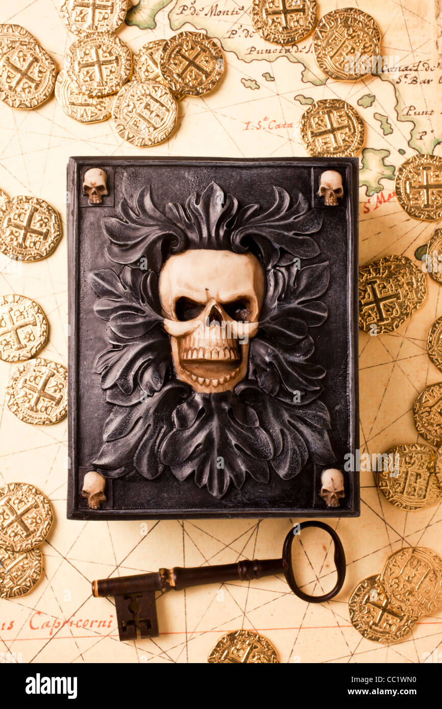 Totenkopf Schatulle mit Skelettschlüssel und Goldmünzen auf alte Karte Stockfoto