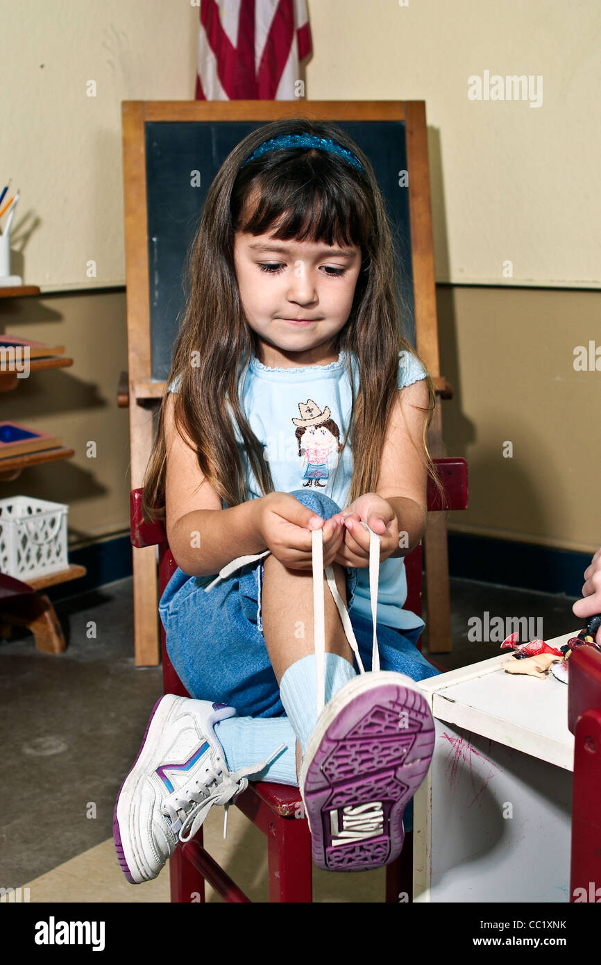 4-5 Jahre Jahre alt Mädchen lernen, ihre Schuhe im Klassenzimmer zu binden. Herr © Myrleen Pearson Stockfoto