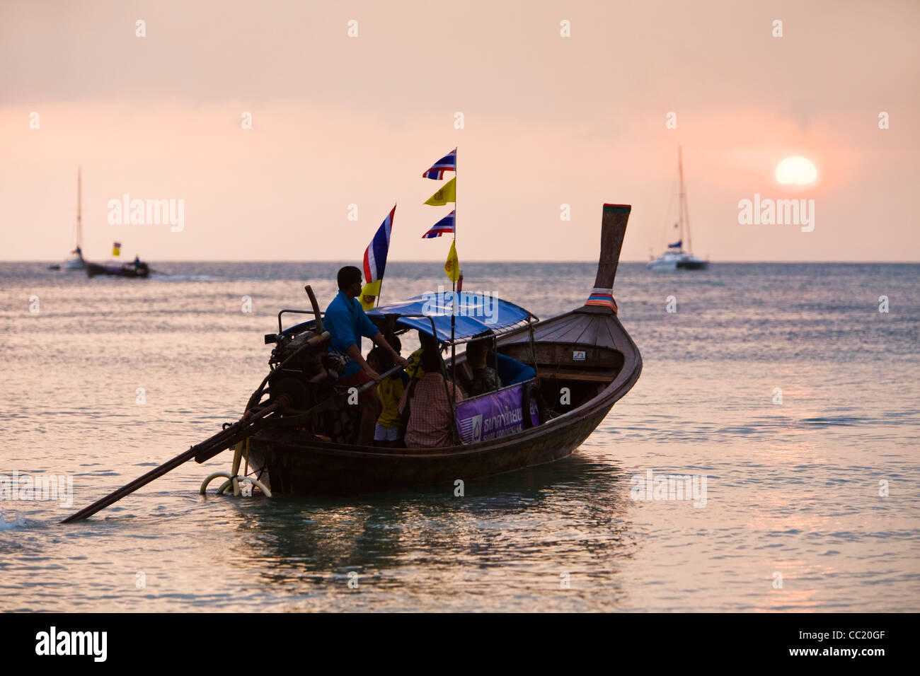 Longtail-Boot mit Passagieren bei Sonnenuntergang. Railay, Krabi, Thailand Stockfoto