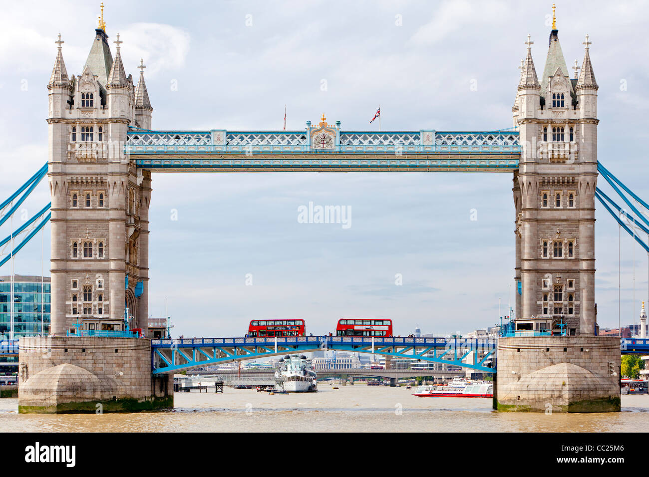 Kreuzfahrt Schiffe, die Touristen auf eine Fahrt auf der Themse und Doppeldecker-Busse, die Tower Bridge überqueren. Stockfoto