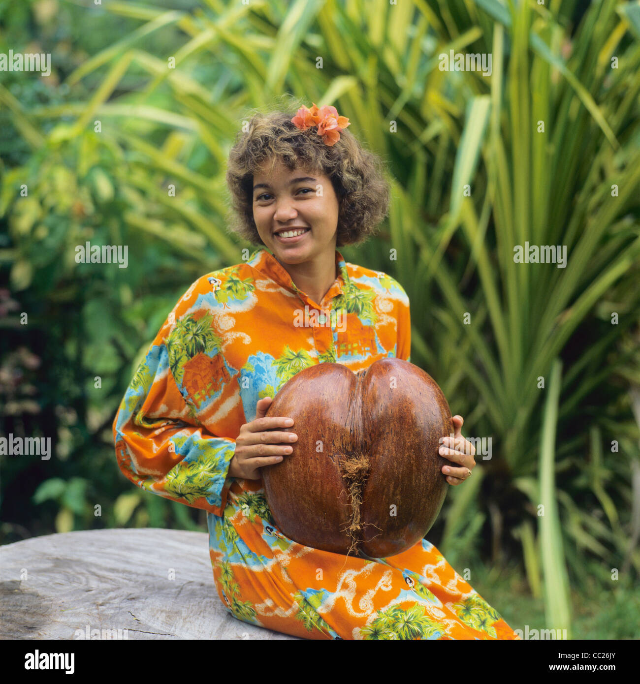 Junge kreolische Frau mit einer Coco de Mer Nuss, Praslin Insel, Seychellen Inseln, Ostafrika, Stockfoto