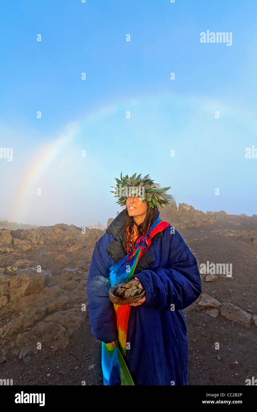 Barbara Bohonu, spirituell/kulturelle Heiler genießen einen Regenbogen kurz nach Sonnenaufgang am Haleakala Krater, Maui, Hawaii, USA. Stockfoto