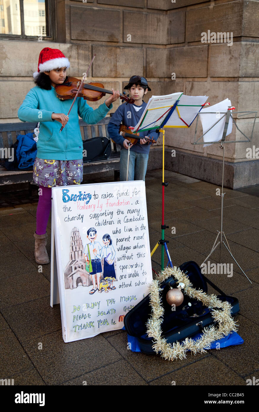 Kinder auf den Straßen von Cambridge als Straßenmusikant Geld für Kambodscha, Cambridge UK Stockfoto