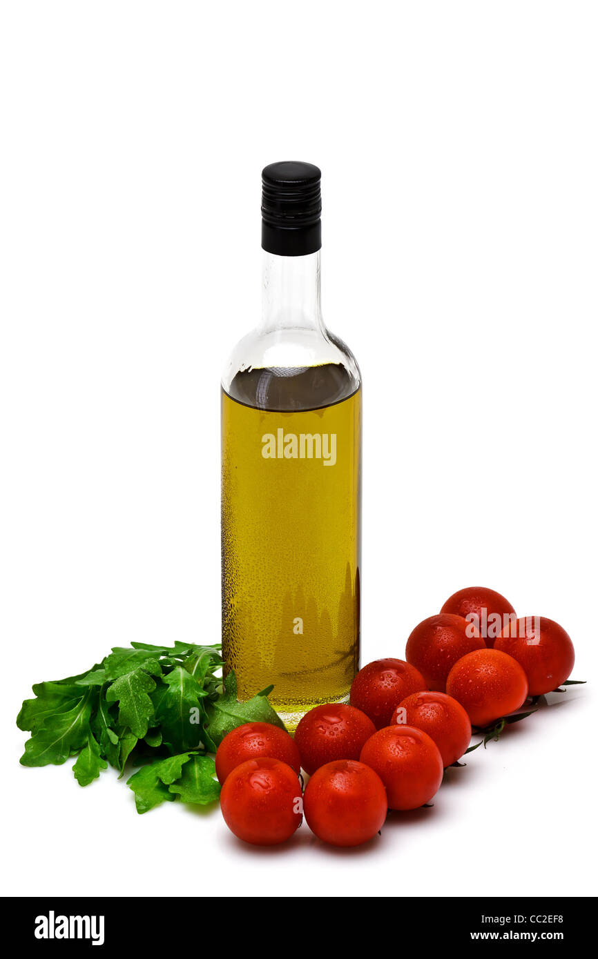 Flasche Olivenöl mit Kirsche und Rucola auf weißem Hintergrund Stockfoto