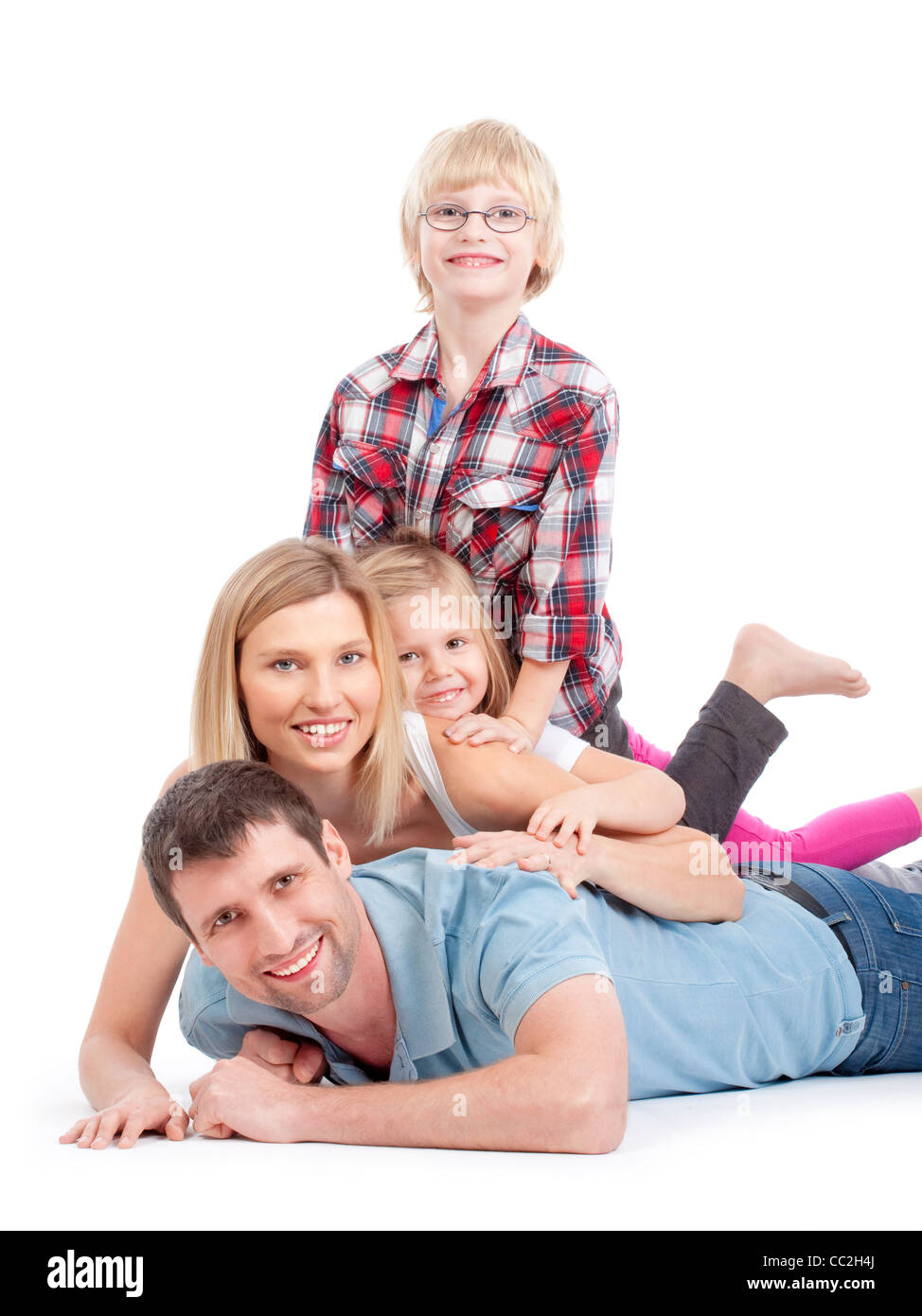 glückliche Familie Spaß liegen übereinander in einem Stapel - isoliert auf weiss Stockfoto
